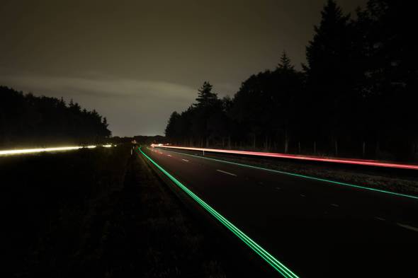 Carretera que se carga durante el da y brilla por la noche
